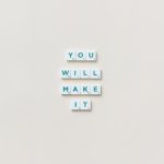 Motivational phrase 'You Will Make It' made from Scrabble tiles on a neutral background.